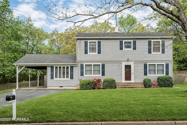 colonial-style house featuring asphalt driveway, a chimney, an attached carport, a shingled roof, and entry steps