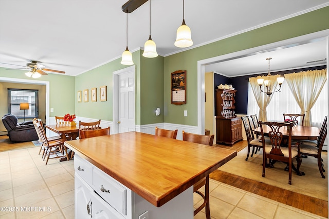 dining room with ornamental molding, light tile patterned flooring, ceiling fan, and a chandelier
