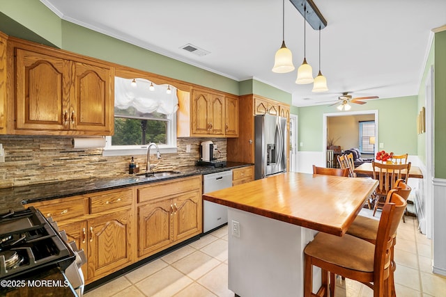 kitchen featuring stainless steel fridge with ice dispenser, a sink, dishwasher, plenty of natural light, and crown molding