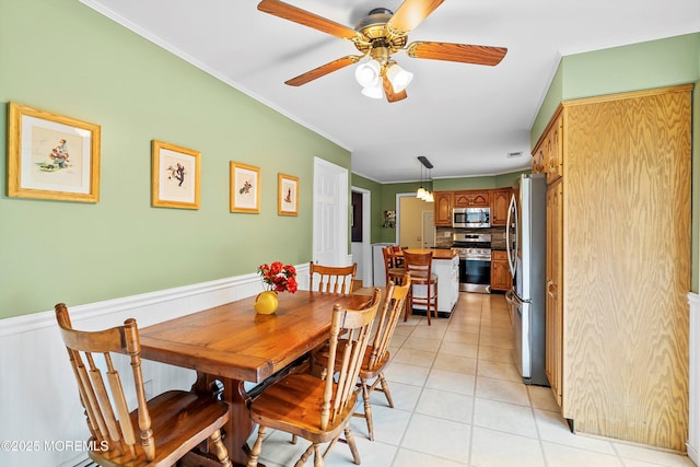 dining room featuring light tile patterned floors, a ceiling fan, and ornamental molding