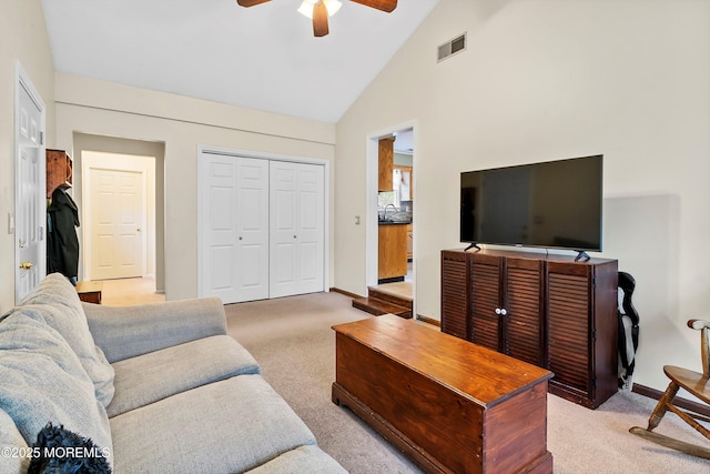 living area featuring ceiling fan, light carpet, high vaulted ceiling, and baseboards
