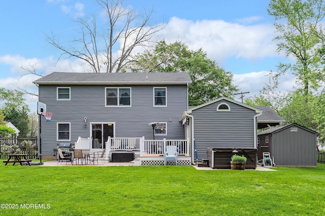 rear view of house with a hot tub, a patio, a wooden deck, a storage shed, and an outbuilding