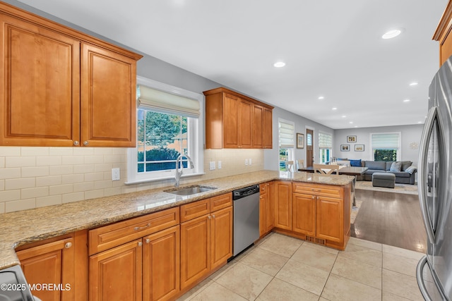 18 Franklin Pkwy, West Long Branch, NJ 07764 - kitchen featuring appliances with stainless steel finishes, open floor plan, a peninsula, a sink, and light stone countertops