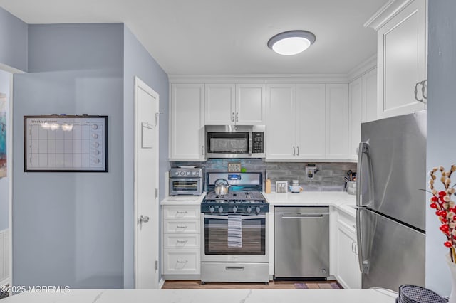 3403 Bridge Ave Unit 2, Point Pleasant, NJ 08742 - kitchen with stainless steel appliances, white cabinetry, decorative backsplash, and light stone countertops