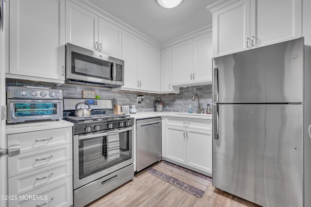 3403 Bridge Ave Unit 2, Point Pleasant, NJ 08742 - kitchen with appliances with stainless steel finishes, a sink, light countertops, white cabinets, and backsplash