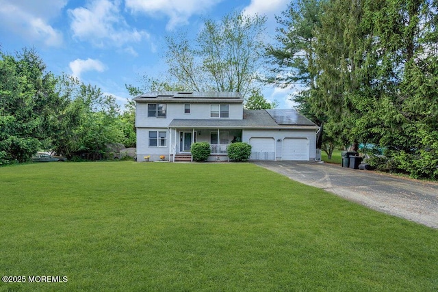 view of front of property featuring covered porch, a garage, solar panels, a front yard, and driveway