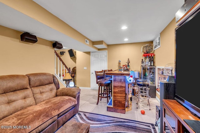 living room with a bar, tile patterned floors, recessed lighting, stairs, and baseboards