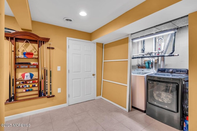 laundry room featuring washer and dryer, baseboards, and tile patterned flooring