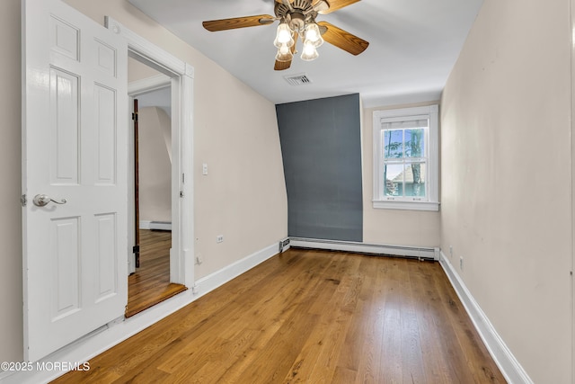 46 Grand Tour, Highlands, NJ 07732 - unfurnished bedroom featuring a baseboard heating unit, wood finished floors, a baseboard radiator, baseboards, and a ceiling fan