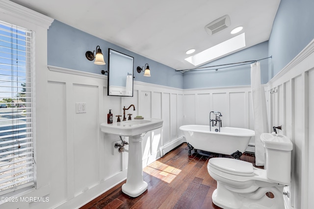 46 Grand Tour, Highlands, NJ 07732 - bathroom featuring a decorative wall, a skylight, wainscoting, a freestanding bath, and wood finished floors