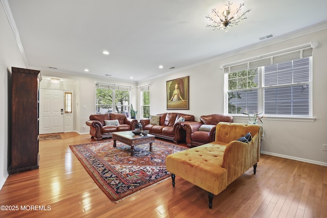 living room with light wood-style floors, ornamental molding, baseboards, and recessed lighting