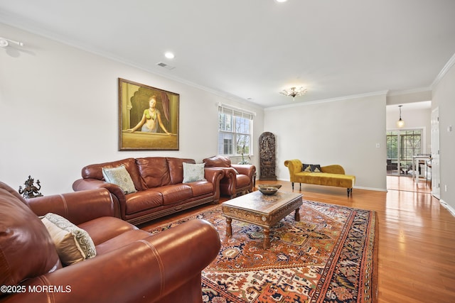 living area with light wood-type flooring, crown molding, recessed lighting, and baseboards