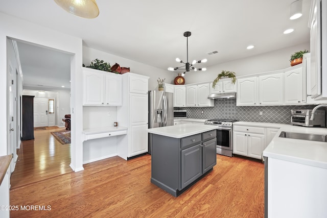 kitchen featuring stainless steel appliances, gray cabinets, white cabinetry, and recessed lighting