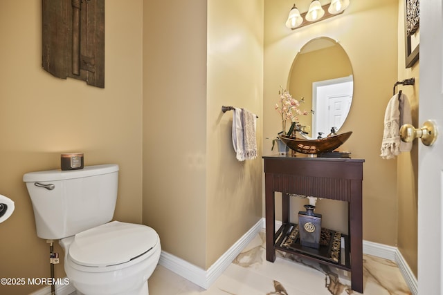 half bath with toilet and baseboards