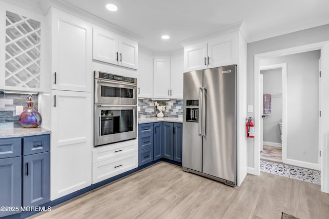 3 Toledo Dr, Brick, NJ 08723 - kitchen featuring appliances with stainless steel finishes, blue cabinetry, white cabinetry, light wood-style flooring, and decorative backsplash