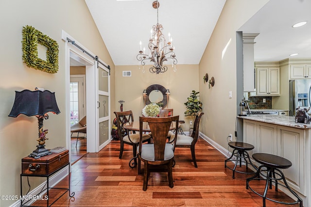 178 Loganberry Ln, Freehold, NJ 07728 - dining area with a barn door, light wood-type flooring, vaulted ceiling, a chandelier, and baseboards