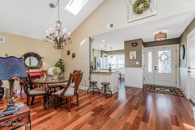 178 Loganberry Ln, Freehold, NJ 07728 - dining area featuring a chandelier, a skylight, dark wood finished floors, wainscoting, and high vaulted ceiling