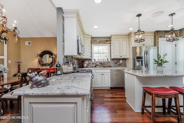 178 Loganberry Ln, Freehold, NJ 07728 - kitchen featuring appliances with stainless steel finishes, a chandelier, a sink, dark wood-style flooring, and a breakfast bar area