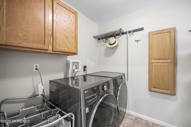 laundry area featuring cabinet space, washing machine and dryer, baseboards, and light tile patterned flooring
