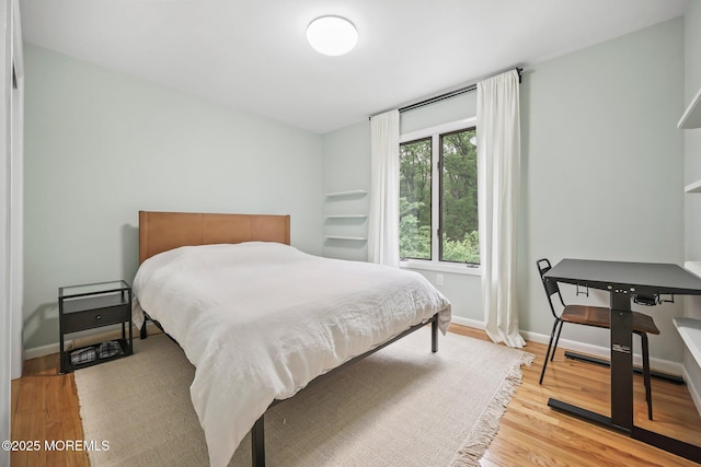bedroom with light wood-style flooring and baseboards