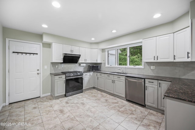 kitchen with stainless steel appliances, a sink, tasteful backsplash, white cabinets, and recessed lighting