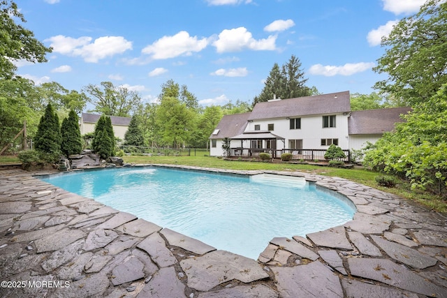 swimming pool featuring a deck and a yard