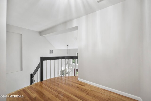 stairway featuring wood finished floors, baseboards, and vaulted ceiling