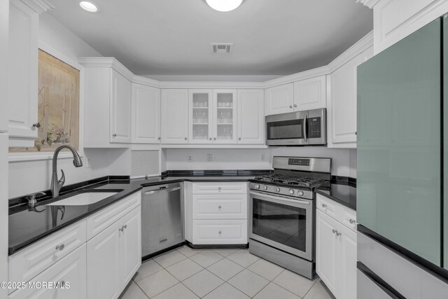 687 Princeton Ave, Brick, NJ 08724 - kitchen with stainless steel appliances, a sink, dark countertops, white cabinetry, and light tile patterned floors