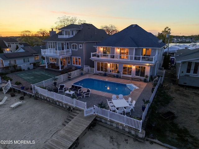 687 Princeton Ave, Brick, NJ 08724 - back of house at dusk featuring a balcony, a fenced backyard, and a patio