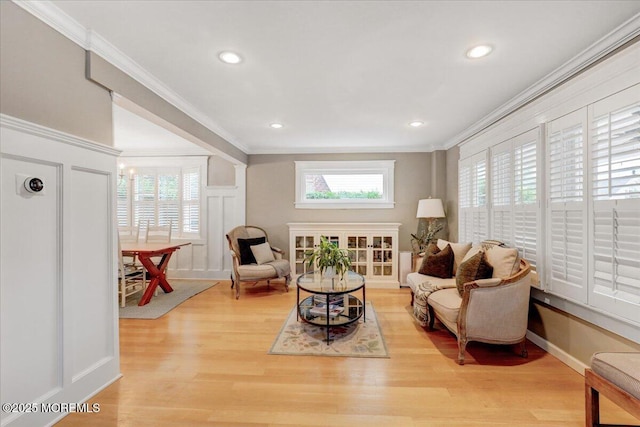 sitting room featuring ornamental molding, healthy amount of natural light, light wood finished floors, a decorative wall, and recessed lighting