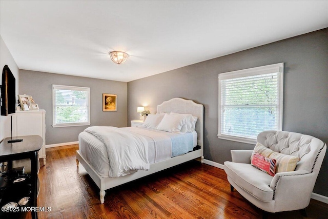 bedroom featuring baseboards and dark wood-style flooring