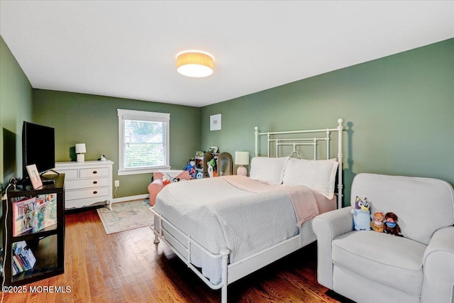 bedroom featuring wood finished floors and baseboards