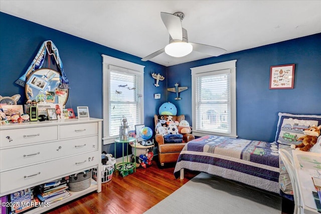 bedroom featuring multiple windows, wood finished floors, and a ceiling fan