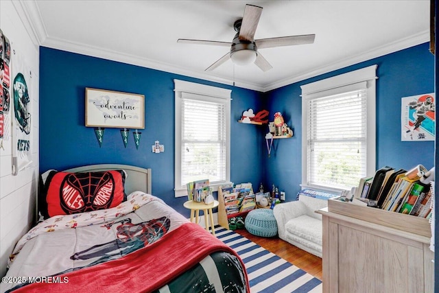 bedroom featuring wood finished floors, crown molding, and a ceiling fan