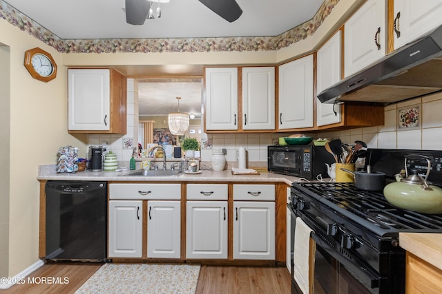 293 Gloucester Ct, Matawan, NJ 07747 - kitchen featuring black appliances, a sink, under cabinet range hood, white cabinetry, and light countertops