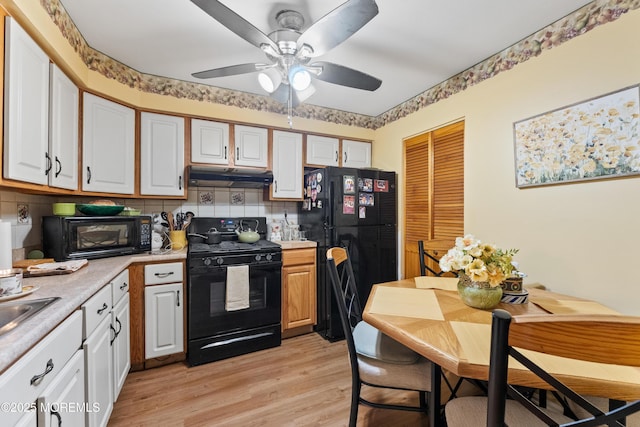 293 Gloucester Ct, Matawan, NJ 07747 - kitchen with black appliances, under cabinet range hood, light countertops, tasteful backsplash, and white cabinets