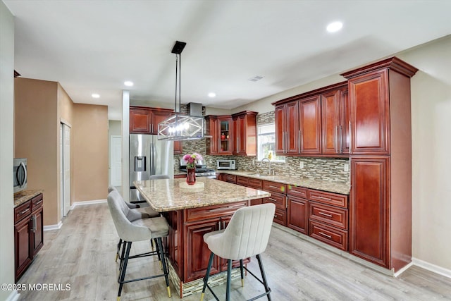 1041 Aumack Rd, Jackson, NJ 08527 - kitchen featuring appliances with stainless steel finishes, reddish brown cabinets, decorative backsplash, light wood-style flooring, and recessed lighting