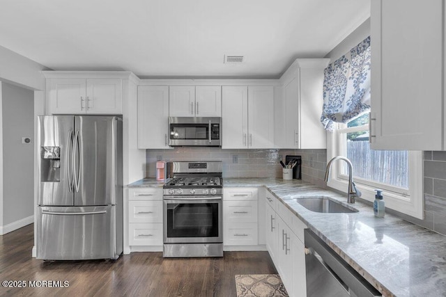 37 Bimini Rd, Brick, NJ 08723 - kitchen with stainless steel appliances, a sink, light stone counters, white cabinetry, and decorative backsplash