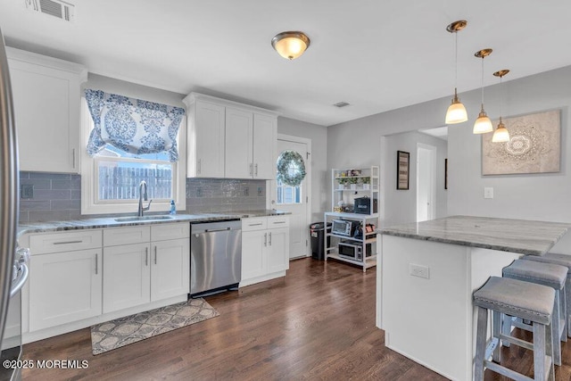 37 Bimini Rd, Brick, NJ 08723 - kitchen with stainless steel dishwasher, a sink, light stone counters, dark wood-type flooring, and white cabinets