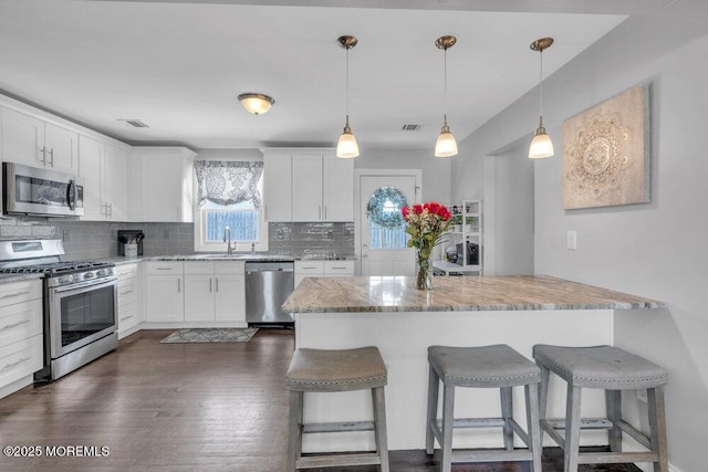 37 Bimini Rd, Brick, NJ 08723 - kitchen with stainless steel appliances, a kitchen bar, backsplash, and white cabinets