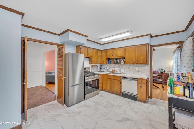 kitchen featuring appliances with stainless steel finishes, light countertops, brown cabinetry, light marble finish flooring, and a sink
