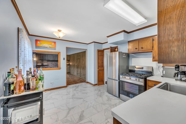 kitchen with stainless steel appliances, crown molding, baseboards, light countertops, and a sink
