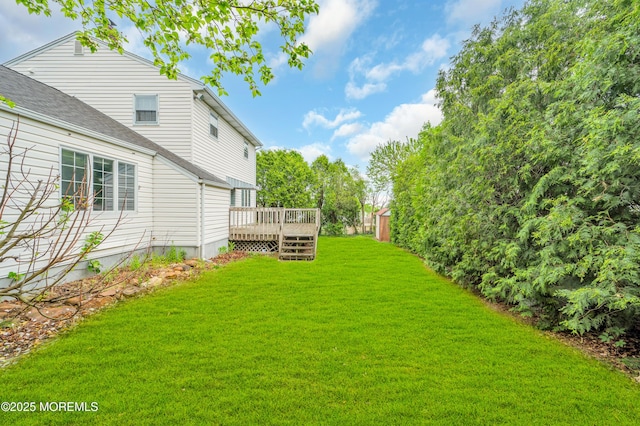 view of green lawn featuring a deck