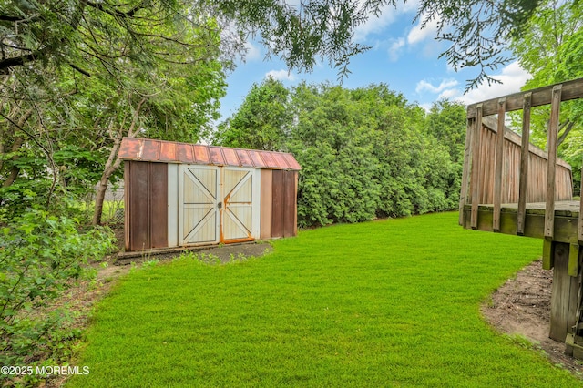 view of green lawn featuring a storage unit and an outdoor structure