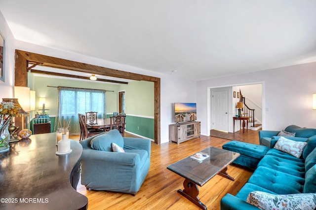 living area featuring stairway and wood finished floors