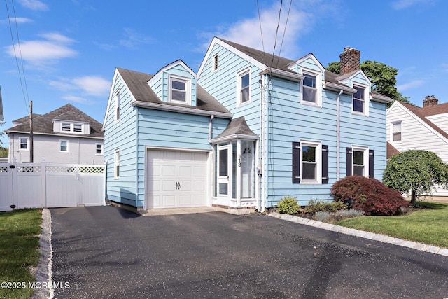view of front of home featuring fence, a garage, a chimney, and driveway