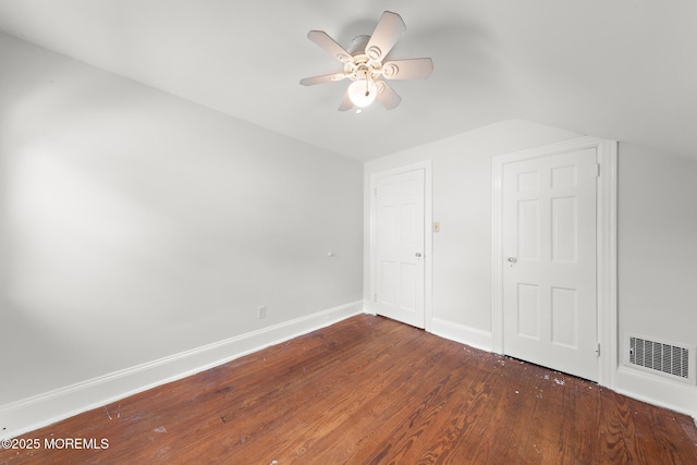 unfurnished bedroom featuring wood finished floors, vaulted ceiling, baseboards, and a ceiling fan