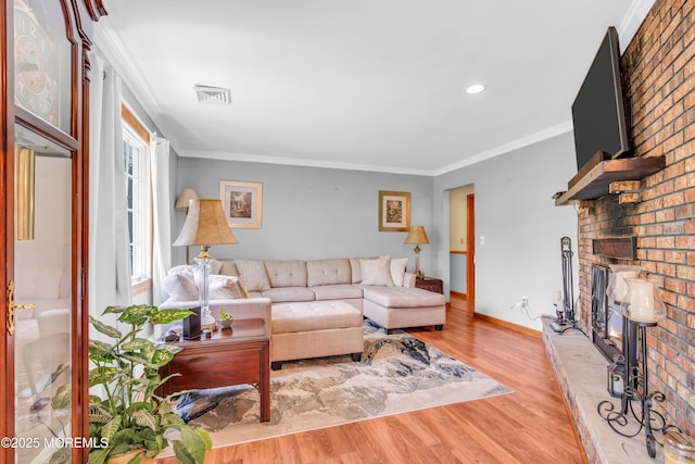 living area with ornamental molding, wood finished floors, a fireplace, baseboards, and recessed lighting
