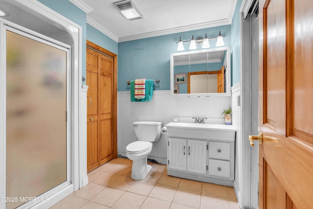 full bath with a stall shower, tile patterned flooring, ornamental molding, wainscoting, and toilet