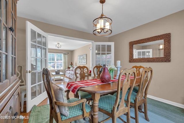 dining room with a chandelier and baseboards